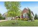 Landscaped front yard with vibrant green grass, mature trees, and brick facade at 19281 Scofield Ridge Blvd, Westfield, IN 46074