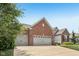 Spacious three-car garage with brick exterior and a concrete driveway and manicured lawn at 19281 Scofield Ridge Blvd, Westfield, IN 46074
