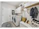 This laundry room features white cabinets, a front-loading washer and dryer, and a bench with decorative pillows at 19281 Scofield Ridge Blvd, Westfield, IN 46074