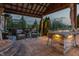 Inviting covered patio with a fire pit, lounge seating, and views of the lush backyard at 19281 Scofield Ridge Blvd, Westfield, IN 46074