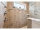Walk-in shower featuring neutral stone tile surround, and a window for natural light at 19281 Scofield Ridge Blvd, Westfield, IN 46074
