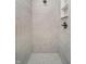 Modern shower featuring marble-style tile walls, a rainfall shower head and a recessed shelf for storage at 202 Asbury Dr, Anderson, IN 46013