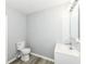Bright bathroom featuring a modern vanity, toilet, and wood-look vinyl flooring at 2413 Fowler St, Anderson, IN 46012