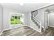 Open-concept living space featuring wood-look floors, stairs, and sliding glass doors leading to the backyard at 2413 Fowler St, Anderson, IN 46012