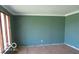 Green living room featuring large windows allowing natural light and hardwood floor at 311 Fall Creek Dr, Anderson, IN 46013