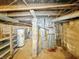 Unfinished basement area with exposed beams, hot water tank, and various utilities visible at 3251 Mars Hill St, Indianapolis, IN 46221