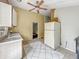 Kitchen area with white cabinetry, tile flooring, and basic appliances and large refrigerator at 3251 Mars Hill St, Indianapolis, IN 46221