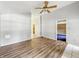 Bright living room with wood-look floors, ceiling fan, and entrance to an adjacent room at 3251 Mars Hill St, Indianapolis, IN 46221
