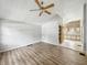 Spacious living room with wood-look floors and a ceiling fan, leading into the kitchen at 3251 Mars Hill St, Indianapolis, IN 46221