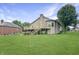 Backyard featuring a large deck, stairway, brick chimney, grass and a leafy tree at 3287 Buckmoor Pkwy, Greenwood, IN 46143