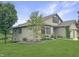 Home's exterior with manicured lawn, landscaping, and mature trees near a scenic pond at 3287 Buckmoor Pkwy, Greenwood, IN 46143