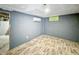 An unfinished basement bedroom showcasing blue accent walls and laminated floor at 3422 Hillside Ave, Indianapolis, IN 46218