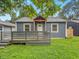 This home has a front porch and is surrounded by lush green landscaping and clear, blue skies at 3422 Hillside Ave, Indianapolis, IN 46218