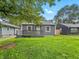 Quaint home with a front porch, fresh green grass, and leafy trees overhead at 3422 Hillside Ave, Indianapolis, IN 46218