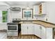 Kitchen featuring stainless steel appliances, white cabinets, and ample counter space at 3422 Hillside Ave, Indianapolis, IN 46218