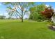 Large backyard with a well-kept lawn, mature trees, and landscaping offering a private outdoor space at 3841 Meridee Dr, Indianapolis, IN 46237