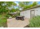 Relaxing backyard patio with outdoor dining set, complemented by lush greenery and a cozy fire pit at 3841 Meridee Dr, Indianapolis, IN 46237
