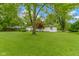 Lush backyard featuring a well-maintained lawn and mature trees providing shade and privacy at 3841 Meridee Dr, Indianapolis, IN 46237