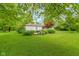 Lush backyard with mature trees, vibrant flowers, and a well-maintained lawn, creating a serene outdoor oasis at 3841 Meridee Dr, Indianapolis, IN 46237