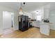 This light, bright kitchen features a black refrigerator and stainless appliances and new flooring at 3841 Meridee Dr, Indianapolis, IN 46237