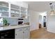 Open kitchen layout with a view of the living room, white cabinets, and wooden flooring at 3841 Meridee Dr, Indianapolis, IN 46237