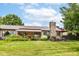 Extensive backyard with covered patio, stone chimney, lush landscaping, and serene views, perfect for outdoor enjoyment at 392 Sandbrook Dr, Noblesville, IN 46062
