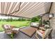 Relaxing covered deck overlooking a lush green landscape, furnished with comfortable seating and a retractable awning at 392 Sandbrook Dr, Noblesville, IN 46062