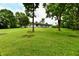 Lush green backyard with mature trees framing the home's exterior and a charming deck at 4115 Tansel Rd, Indianapolis, IN 46234