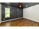 Bedroom with a dark accent wall, wood floors, and lots of natural light from the window at 4115 Tansel Rd, Indianapolis, IN 46234
