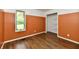 Cozy bedroom with wood floors, orange accent wall, and a bright window at 4115 Tansel Rd, Indianapolis, IN 46234