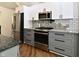 Updated kitchen with white and gray cabinets, stainless steel appliances, and unique backsplash tiling at 4115 Tansel Rd, Indianapolis, IN 46234