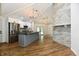 Bright, open kitchen with stone accent wall, gray island, stainless appliances, and wood floors at 4115 Tansel Rd, Indianapolis, IN 46234