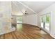 Spacious living room featuring wood floors, stone fireplace, high ceilings, and double doors to the yard at 4115 Tansel Rd, Indianapolis, IN 46234