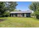 A serene backyard featuring a well-kept lawn and mature trees for privacy, with a view of the home's exterior at 414 S Green St, Brownsburg, IN 46112