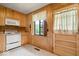 Compact kitchen featuring wooden cabinets, white appliances, and a window providing natural light and ventilation at 414 S Green St, Brownsburg, IN 46112