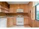 Efficient kitchen with wooden cabinets, a microwave, and a view from the window, creating a pleasant cooking space at 414 S Green St, Brownsburg, IN 46112