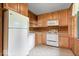 Functional kitchen with wooden cabinets, white appliances, and ample counter space for meal preparation at 414 S Green St, Brownsburg, IN 46112