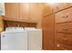 Practical laundry room with wooden cabinets, a washer, a dryer, and convenient storage options for household essentials at 414 S Green St, Brownsburg, IN 46112