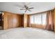 Open-concept living room with neutral carpet, ceiling fan, and large windows creating a bright atmosphere at 414 S Green St, Brownsburg, IN 46112