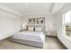 Bright, spacious bedroom with a large platform bed, modern art, neutral tones, and abundant natural light at 4250 Blackford Rd, Bargersville, IN 46106