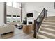 Bright living room boasts soaring ceilings, fireplace, lake views, and staircase at 4250 Blackford Rd, Bargersville, IN 46106