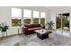 Sun-filled living room with a brown leather sofa and large windows overlooking the backyard at 4250 Blackford Rd, Bargersville, IN 46106