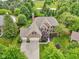 Aerial view shows a spacious brick home with a three-car garage, set on a tree-lined lot at 427 Quincy Pl, Westfield, IN 46074