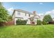 White two-story home with a covered patio featuring outdoor seating and lush green lawn, ideal for entertaining at 427 Quincy Pl, Westfield, IN 46074