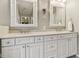 Bright bathroom featuring double sinks with granite countertops, white cabinetry, and decorative framed mirrors at 427 Quincy Pl, Westfield, IN 46074