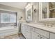 Elegant bathroom with a soaking tub, double vanity with granite countertops, and decorative framed mirrors at 427 Quincy Pl, Westfield, IN 46074