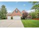 Traditional brick home boasts an attached three car garage and a well manicured front lawn at 427 Quincy Pl, Westfield, IN 46074
