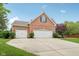 Side view of brick home showing the three car garage, black shutters and manicured landscaping at 427 Quincy Pl, Westfield, IN 46074