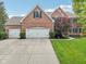 Traditional brick home with a three-car garage and manicured landscaping offers curb appeal and convenience at 427 Quincy Pl, Westfield, IN 46074