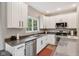 Galley kitchen with white cabinets, stainless steel appliances, granite counters and a window over the sink at 427 Quincy Pl, Westfield, IN 46074